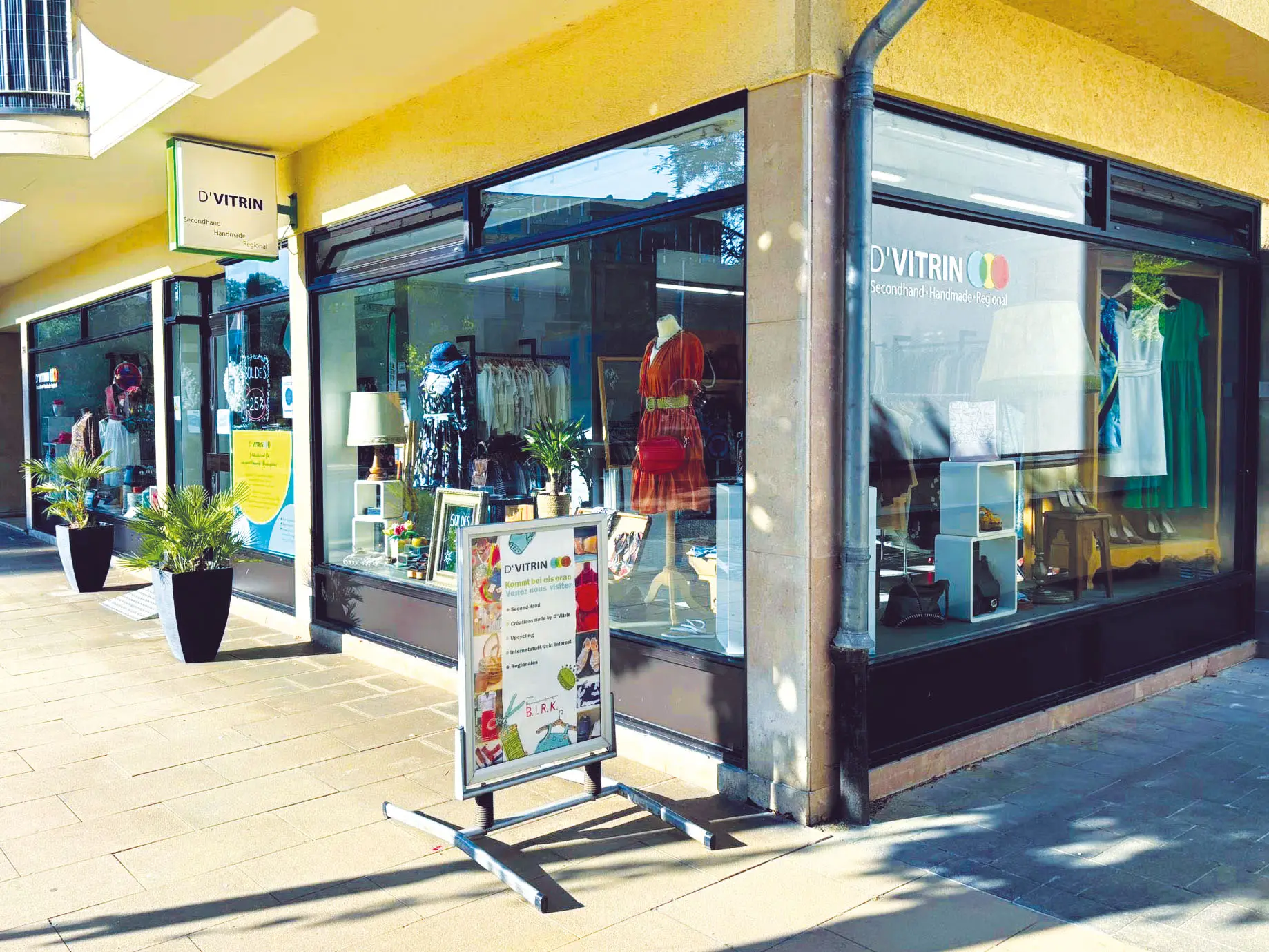 Bunte Kleiderständer mit Secondhand-Kleidung in der Kleederbuttéck von D'Vitrin